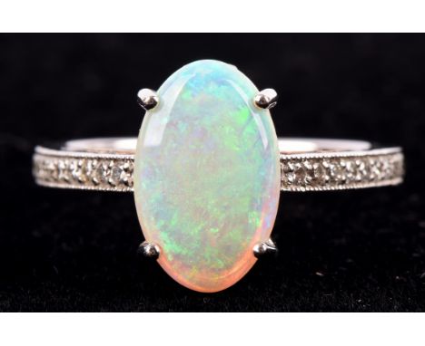 Opal and diamond ring in white metal stamped "18CT", the central oval shaped opal four claw set, with brilliant cut diamond s