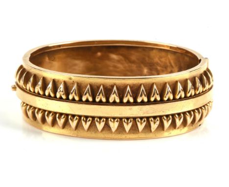 A hinged bangle in unmarked yellow metal tested as 15 ct gold, with applied detailing.Condition Report:  Weight 19.5 grams.Mi