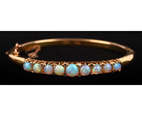 Opal and diamond hinged bangle, set with nine round cabochon cut opals and rose cut diamonds, mount stamped 18 ct, with conce