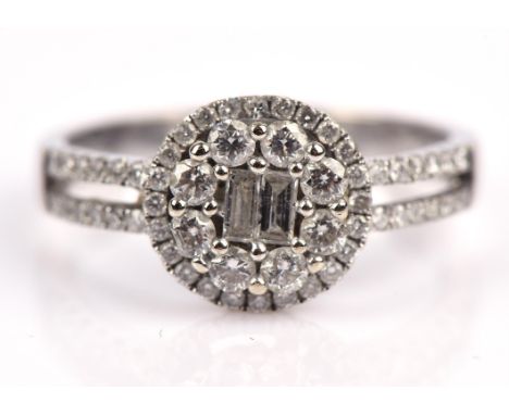A diamond ring, set with two central baguette cut diamonds, with a double surround of round brilliant cut diamonds and diamon