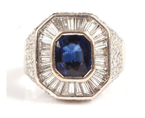 Sapphire and diamond cluster ring, with a central bezel set oval cut sapphire weighing an estimated 2.13 carats, with a surro