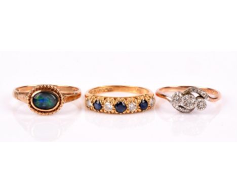 Three rings, including a sapphire and diamond half hoop ring, size N, a three stone diamond crossover ring, size M, both in 1