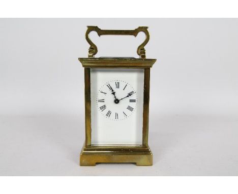 A French brass and glass Anglaise styled case carriage timepiece clock, white enamel dial with Roman numerals with matched bl