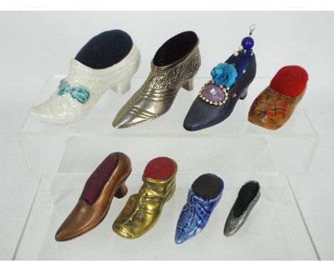 A quantity of shoe or boot form pin cushions to include ceramic, treen, white metal and copper examples, late 19th / early 20