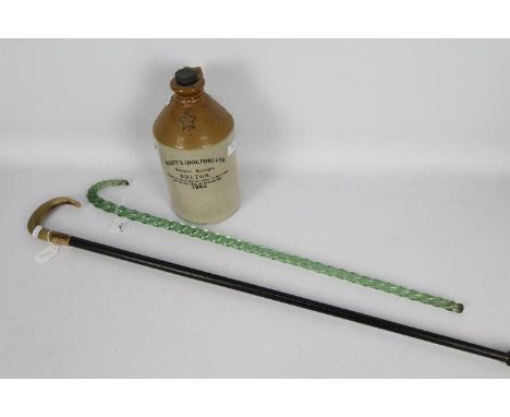 A green glass frigger in the form of a walking stick with twist decoration 74 cm (l), a horn handled walking stick and a Scot