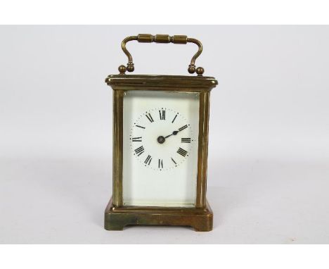 A French brass and glass Corniche styled case carriage timepiece clock, white enamel dial with Roman numerals with matched sp