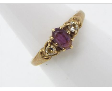 A hallmarked 9 carat yellow gold trilogy ring set with amethyst flanked by two cz stones, size M, approx 1.87 gm