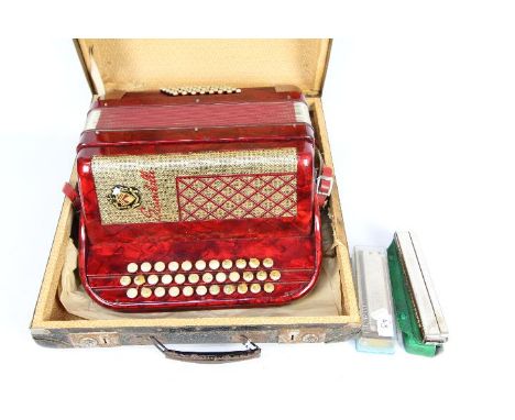 A vintage Scandalli accordion contained in carry case and a Hohner harmonica and one other.