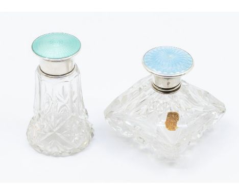 Two George V cut glass vari-shaped scent bottles with stoppers, each with silver and enamelled covers: one with mint green co