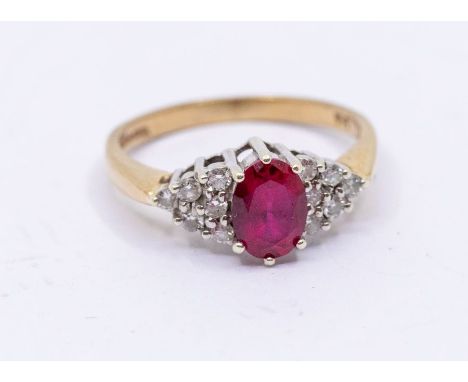 A synthetic ruby and diamond dress ring, comprising a central oval cut synthetic ruby claw with diamonds set to the shoulders