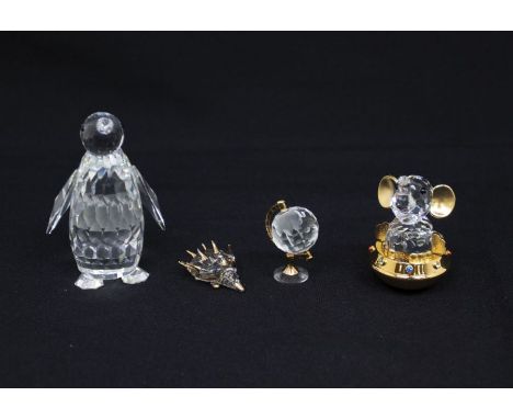 Four Swarovski figures including baby elephant, hedgehog, globe and a penguin, in boxes