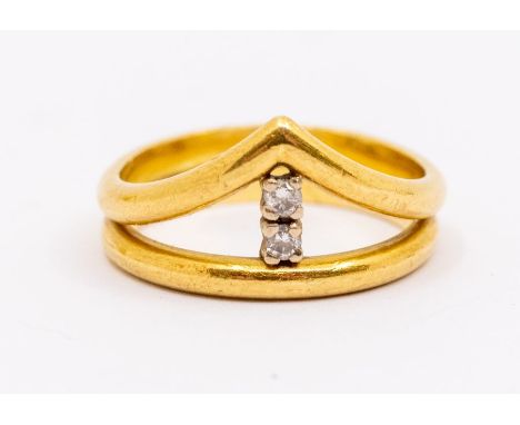 A diamond set 18ct gold wishbone ring comprising two bands, one wishbone shaped inset to the centre with two small claw set b