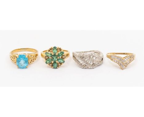 A collection of four 9ct gold dress rings to include a blue topaz solitaire, size N, along with a green stone set floral clus