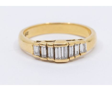 A diamond and 18ct gold eight stone ring, comprising channel set tapered baguette cuts set to the front, width approx 5mm, si