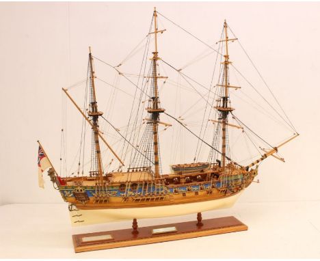 A wooden model ship, 'Royal Caroline', upon wooden stand. Measuring approx. 85cm length x 72cm height x 23cm depth