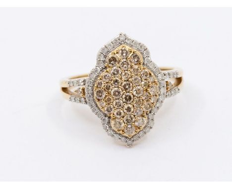 A diamond and 9ct gold cluster ring comprising a Arabic motif grain set with round brilliant cut champagne diamonds within a 