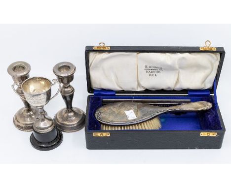 A collection of silver to include: a pair of candlesticks (filled); a small two handled cup and a cased hairbrush &amp; silve