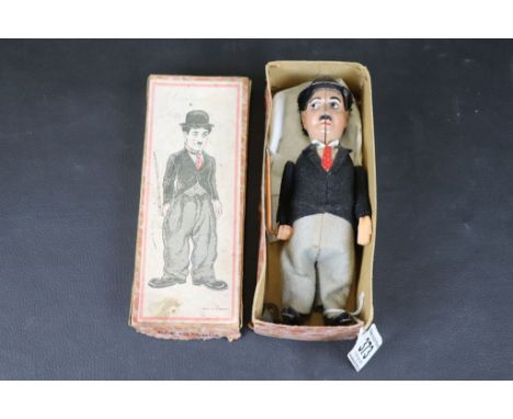 Boxed Schuco Charlie Chaplin B/1454/1 tin plate clockwork figure in black jacket with red tie, tin plate hat, grey trousers w