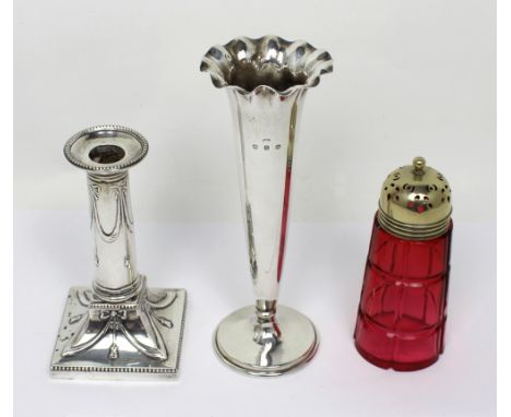 A George V hallmarked silver Neo-Classical loaded candlestick, the column and swept square base decorated with bows and swags