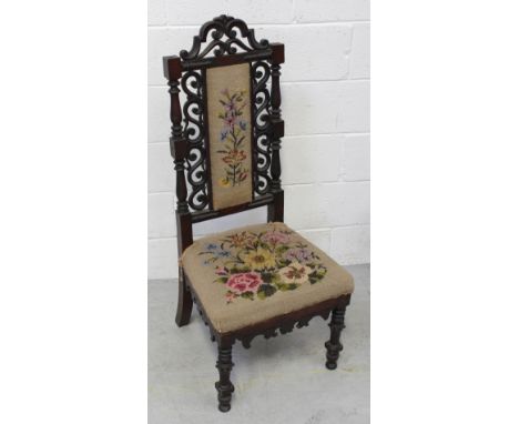 A Victorian scroll carved hall chair with embroidered tapestry seat and back (af).