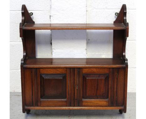 A wall-hanging walnut shelf unit, single shelf over two cupboard doors, 65 x 57cm.