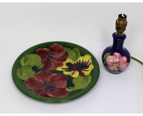 A Moorcroft 'Hibiscus' pattern tube line decorated green ground plate with 'WM' monogram, factory sticker and factory stamps 