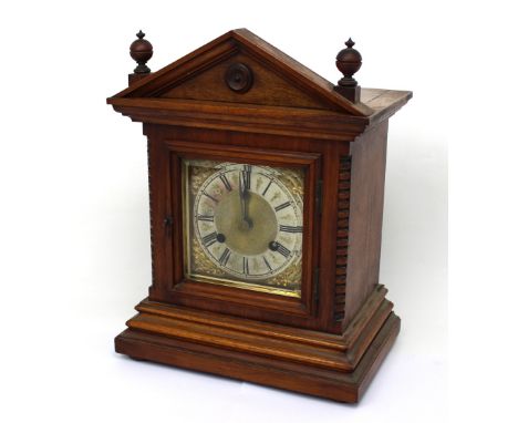 A late 19th/early 20th century rosewood eight-day Grecian-style mantel clock, the gilded and silvered dial set with Roman num