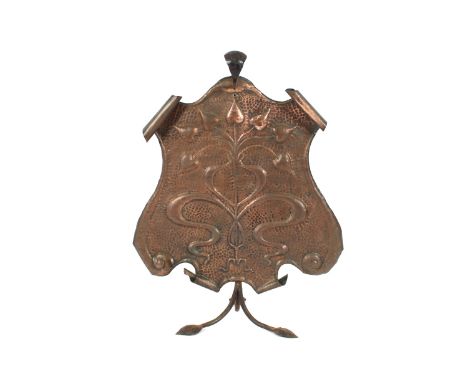 A spot hammered copper and wrought metal fireguard, having raised flower head decoration in the Art Nouveau manner, 72cm high