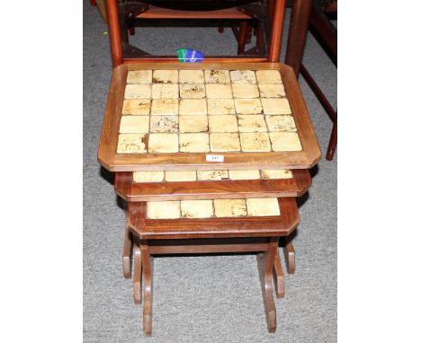 A nest of three teak and tile top coffee tables
