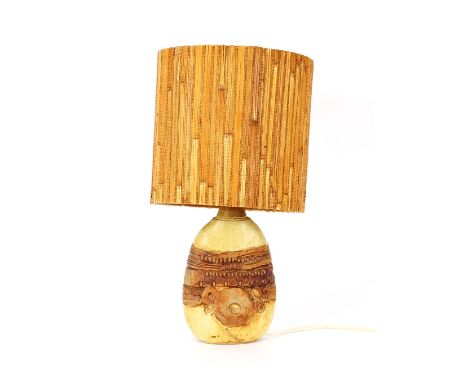 A Bernard Rooke table lamp, having raised stylised decoration complete with shade