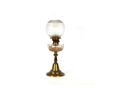 A brass based Arts & Crafts design oil lamp, having clear glass font and etched shade