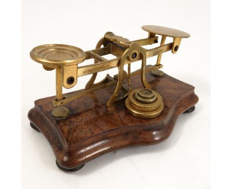 A 19th century S Mordan & Co London set of scales, the gilt metal scales mounted on a shaped walnut base, with four graduated