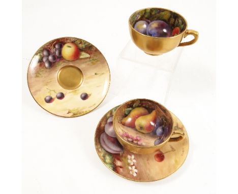 Two Royal Worcester miniature cabinet cups and saucers, the interior of the cups and the saucers hand painted with fruit to a