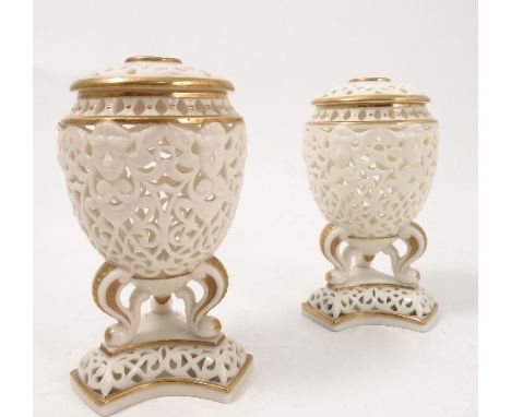 A pair of Royal China Works Worcester pierced covered vases, of egg shape form raised on three supports on platform bases, he