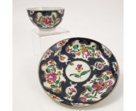 An 18th century tea bowl and saucer, decorated with a scale blue ground and reserve panels of flowers, seal mark to base, cir