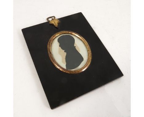 A 19th century painted portrait silhouette of a young boy, in black papier mache frame with gilt leaf hanger, maximum diamete