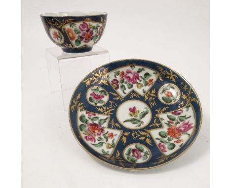 An 18th century Worcester tea bowl and saucer, with fan shaped reserve panels of flowers to a blue ground, circa 1760, height