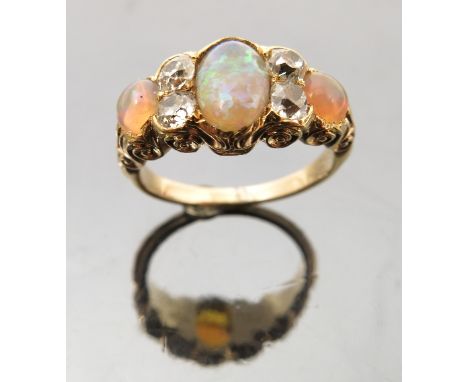 A Victorian opal and diamond ring, the graduated oval cabochons with pairs of old brilliant cuts between, totalling approxima