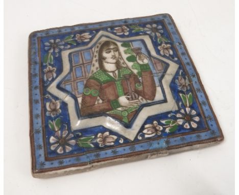 A late 19th century Persian tile, embossed with an eight point star, decorated with a portrait, with flower frame, 6.5ins x 6
