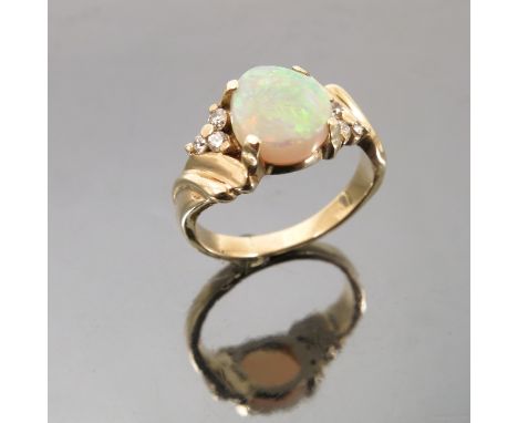 An opal and diamond ring, the asymmetric stone with a trio of diamonds to each side, finger size O, weight 5.2g gross 