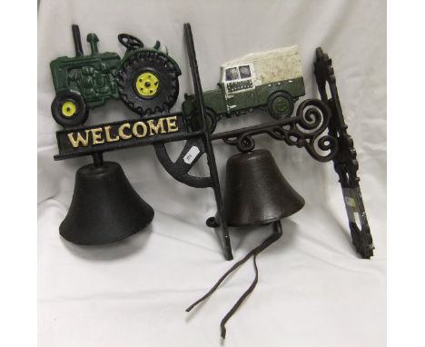 Two iron bells, one bracket decorated with tractor inscribed "Welcome", the other with a Land Rover, and a set of cast hooks 