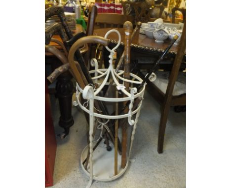 A white painted wrought iron six section umbrella / stick stand and 14 various sticks