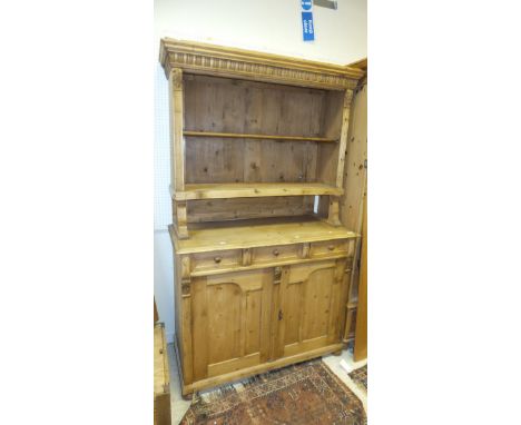 A Continental pine buffet, the upper section with two shelves over three drawers and two cupboard doors