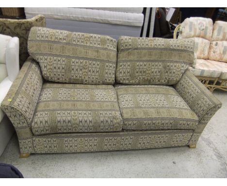 A modern three seat sofa bed in neutral coloured upholstery