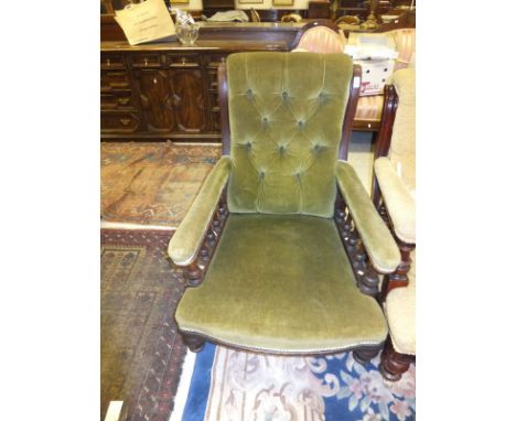 An Edwardian button back armchair in green velour upholstery and exposed mahogany frame, on brown china castors togeather wit