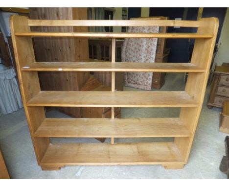 An oak five shelf waterfall style bookcase on bracket feet, together with a long low pine two shelf open bookcase