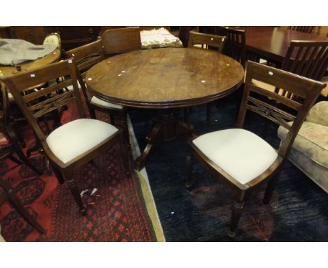 A modern hardwood circular dining table, raised on tripod base, together with four matching chairs