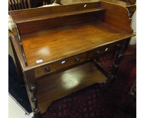 A Victorian mahogany wash stand, the three quarter galleried top with small shelves over two drawers, on turned legs united b