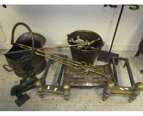 A cast iron grate on two iron and brass dogs, a 19th Century brass coal bucket, pair of brass fire dogs, set of three brass f