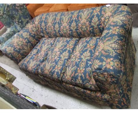 An early 20th Century Chesterfield style three seat sofa with printed floral loose covers